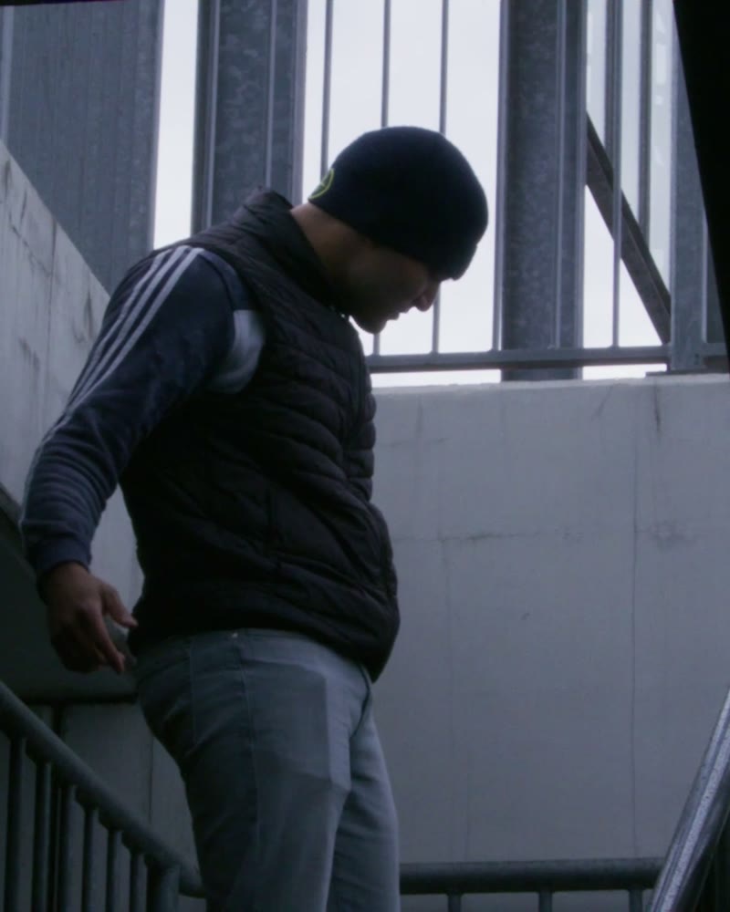 Rapper mit Mütze im Treppenhaus