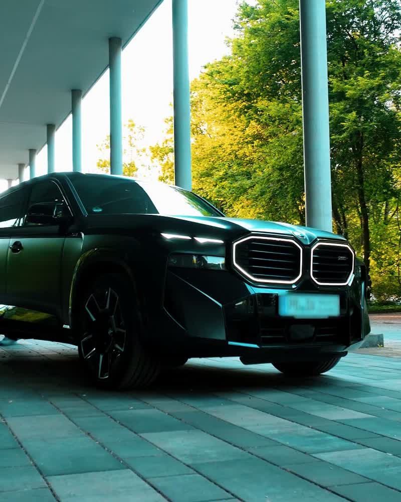 Schwarzer BMW XM vor einer Glasfassade
